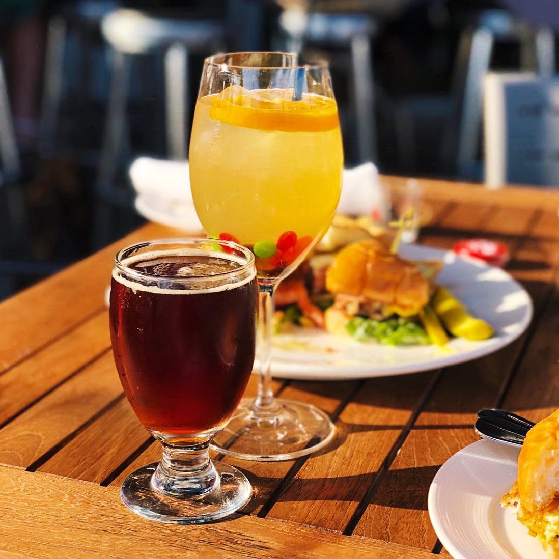 Two beverages on a table with plates of half finished food